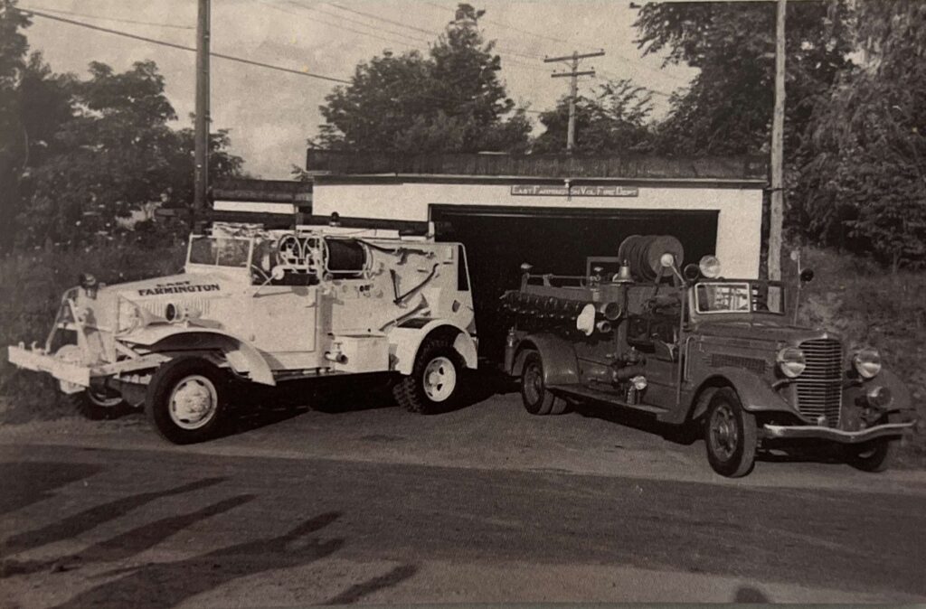 Two fire engines from 1945 parked in front of a garage